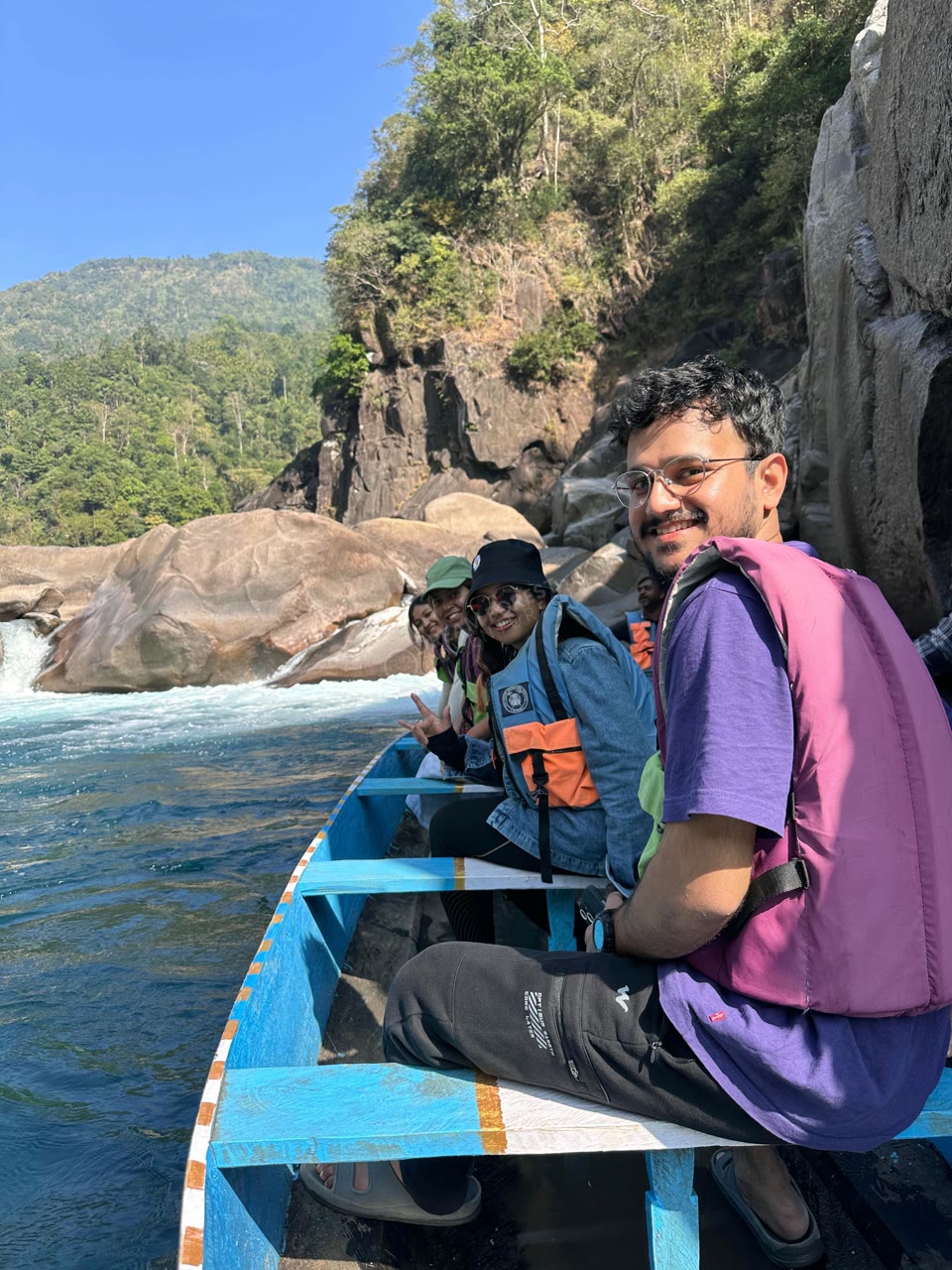 Travelers in a boat near waterfalls in Meghalaya